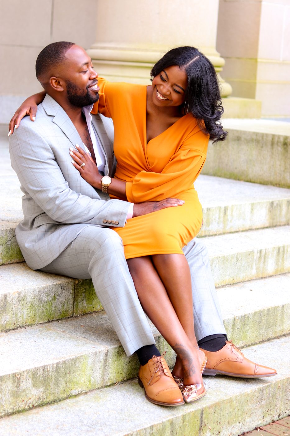 Engaged couple laughing on granite steps