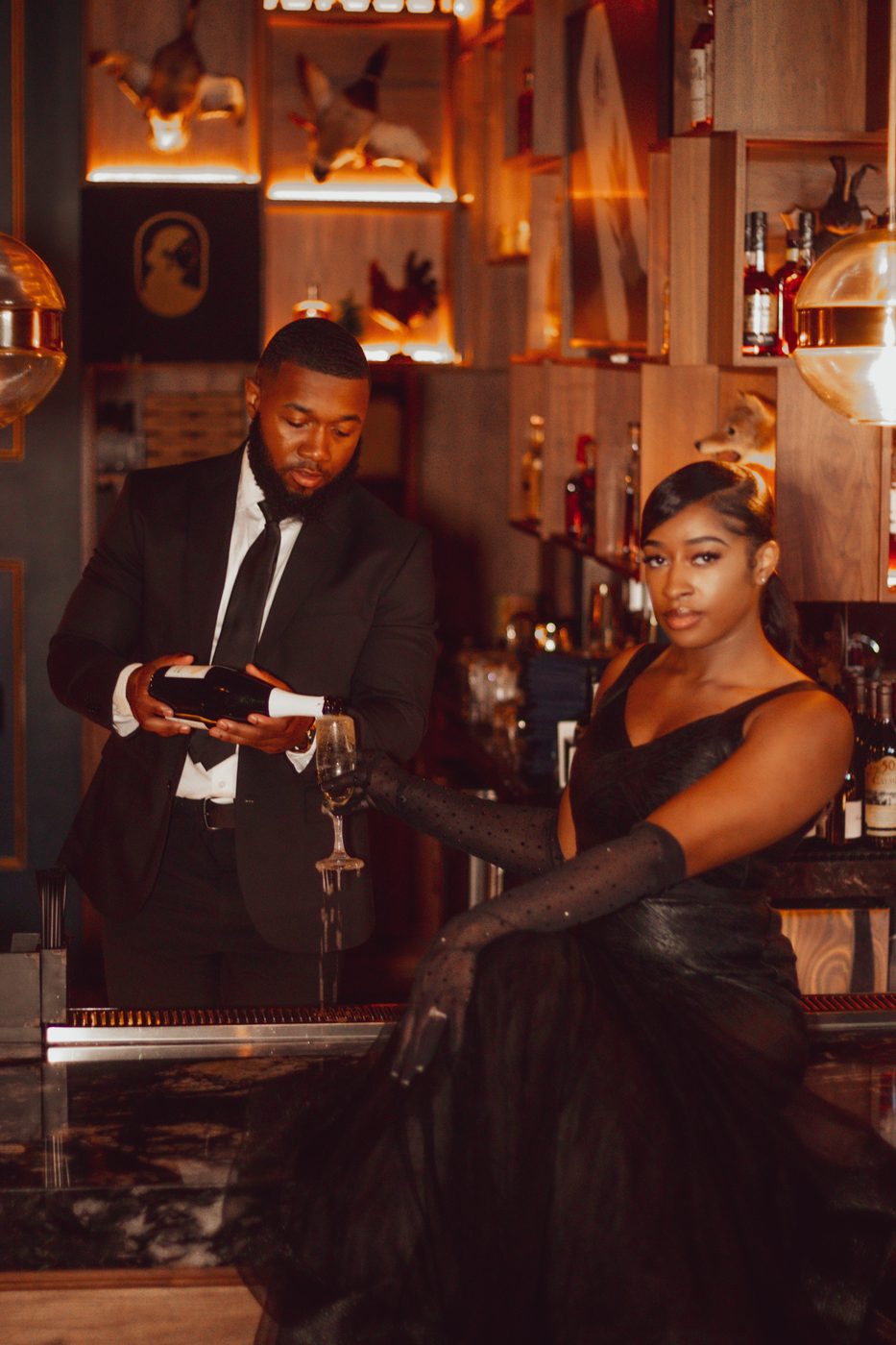 Champagne pour at a moody cocktail bar during a formal session