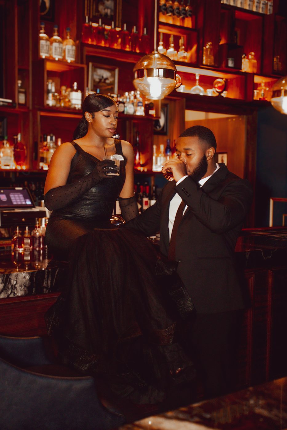 Couple sharing drinks at a warm candlelit bar