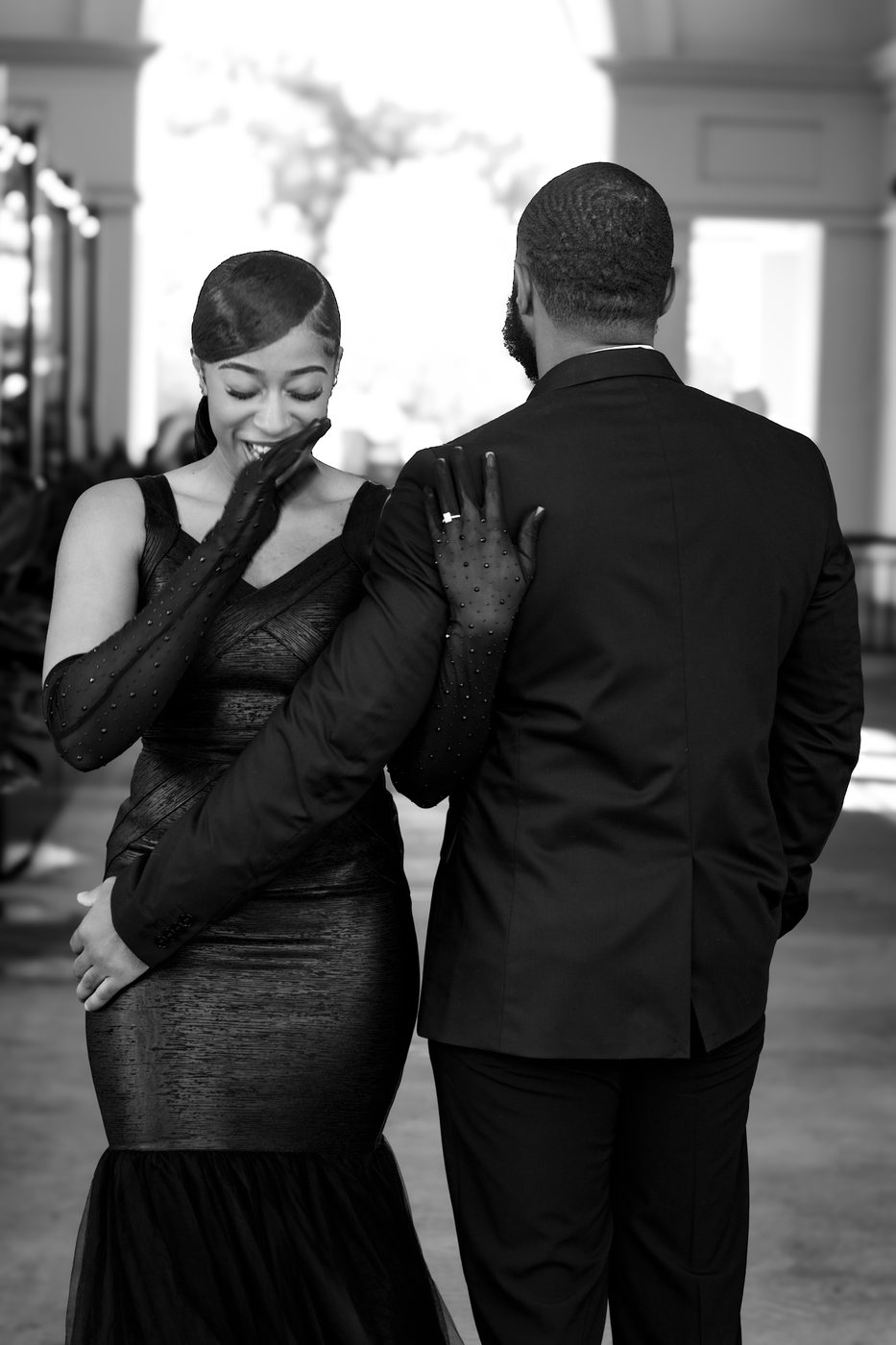 Candid black and white moment with gloved hand on shoulder