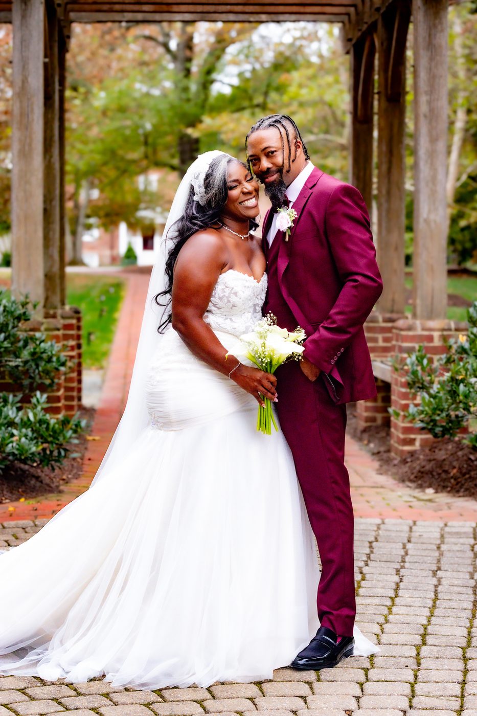 Newlyweds smiling with calla lily bouquet